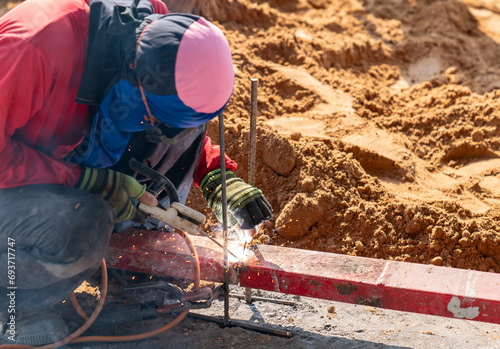 Construction worker welding metal rebar. photo