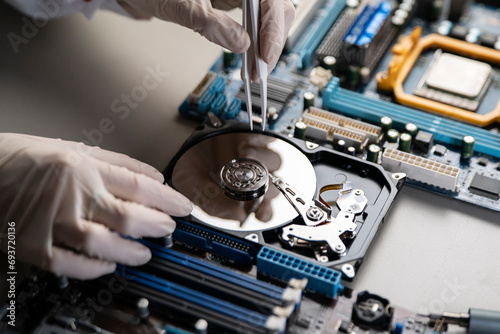 person in gloves work in laboratory, repair broken hdd hard drive photo