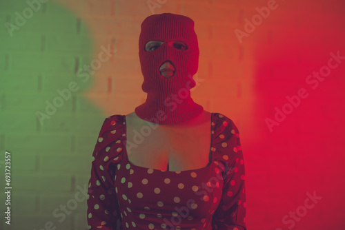 Portrait of a woman wearing a balaclava in red neon light. photo