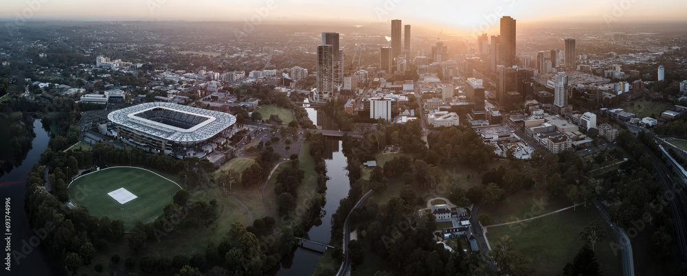 Fototapeta premium Panoramic aerial drone view of Parramatta cbd in Sydney, NSW Australia during a morning sunrise in December 2023