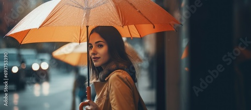 beautiful woman posing using an umbrella in the rain.