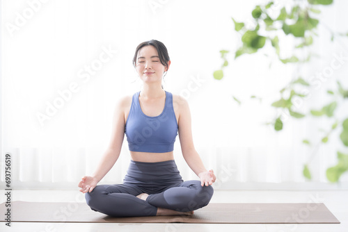Young woman doing yoga Meditating and closing her eyes