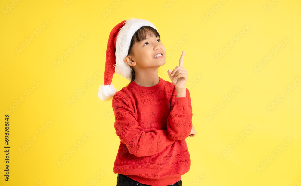 Image of an Asian girl wearing a Christmas sweater and hat posing on a yellow background
Image of an Asian girl wearing a Christmas sweater and hat posing on a yellow background