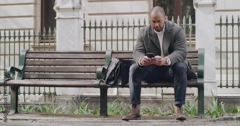 Serious, casual and relaxed man typing text on phone, browsing social media and checking notifications while sitting on a bench in a park. Male entrepreneur and guy reading and replying to emails Serious, casual and relaxed man typing text on phone, browsing social media and checking notifications while sitting on a bench in a park. Male entrepreneur and guy reading and replying to emails