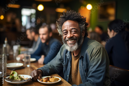 a homeless man in a volunteer cafe at a table. portrait of a smiling unemployed male persona. photo