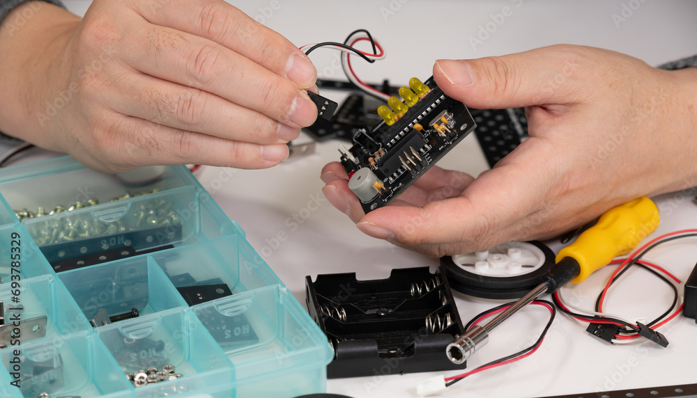Close-up of hands assembling robotics educational toy. STEM education concept Close-up of hands assembling robotics educational toy. STEM education concept