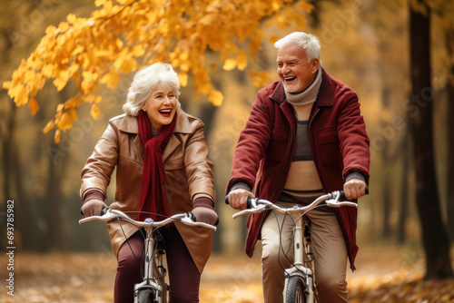 two senior riding bycicle on an autumn park