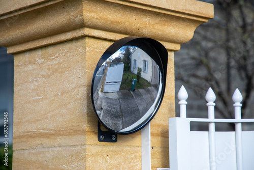 Traffic safety convex mirror on the street in portal private entrance door