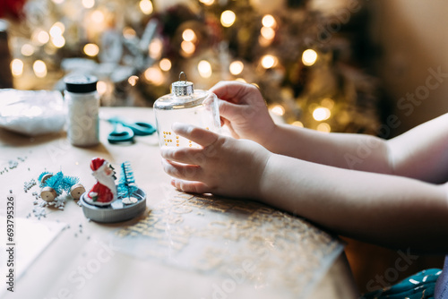 Close up of child's hands making handmade Christmas ornaments photo