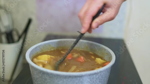 カレーを鍋の中でかき混ぜる
