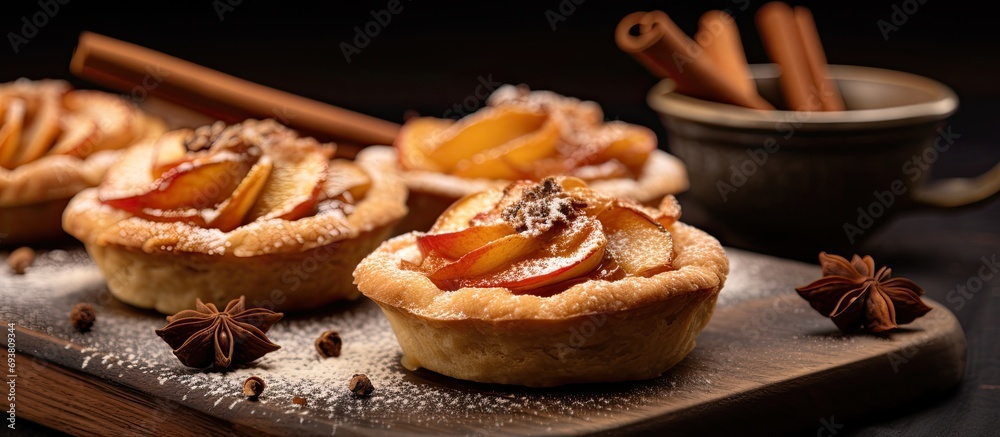 Selective focus close up of apple tartlets with cinnamon and dough decoration.