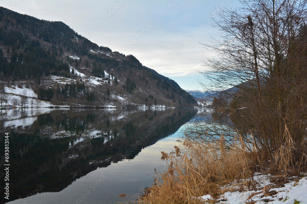 The snowy December landscape at Afritzer See Lake in Carinthia, Austria. Located in the Gegendtal Valley, it is in the Nock Mountains of the Gurktal Alps