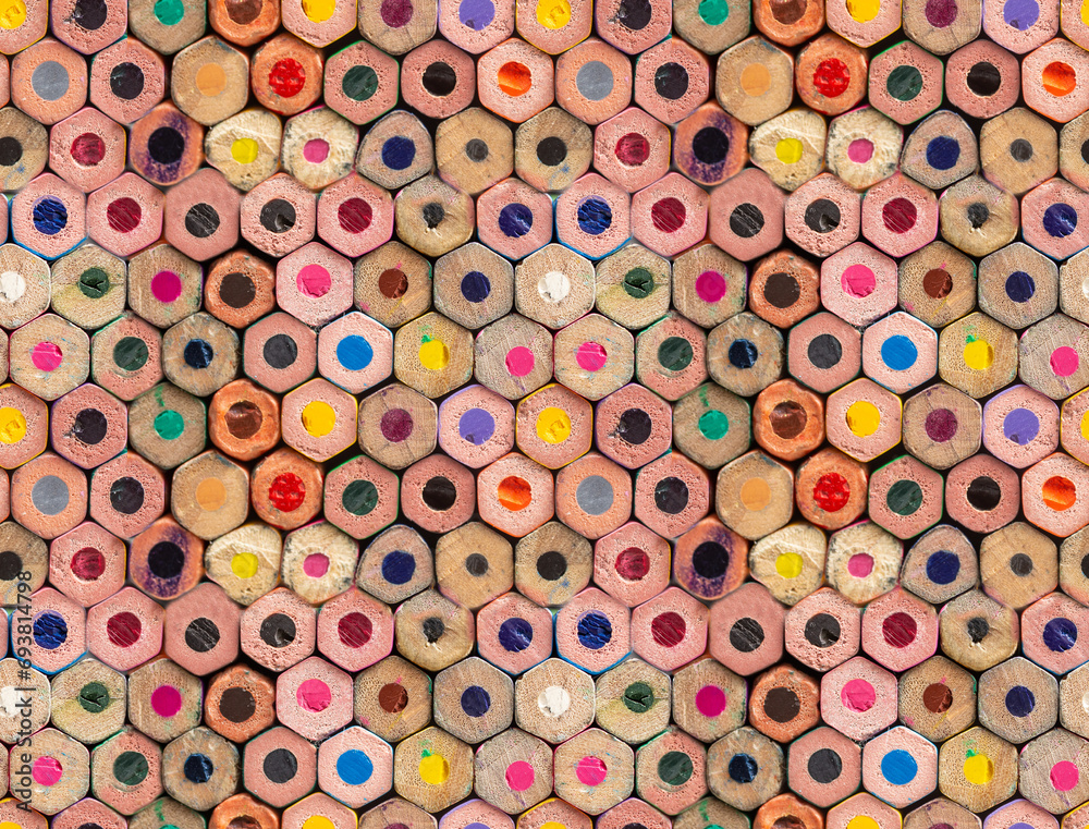 Fototapeta premium Multiple colored wooden crayons bottom arranged in seamless pattern, abstract backdrop, soft focus close up