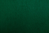 Felt fabric texture with visible fiber, dark green color abstract pattern backdrop, close up