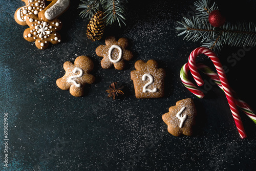 Gingerbread cookies of the form of numbers and 2024. Christmas composition with gingerbread on dark background. Copy space. Flat lay
