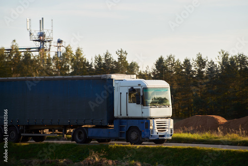 Truck on the highway. Delivery Truck on the road through the countryside. Ground shipping concept.