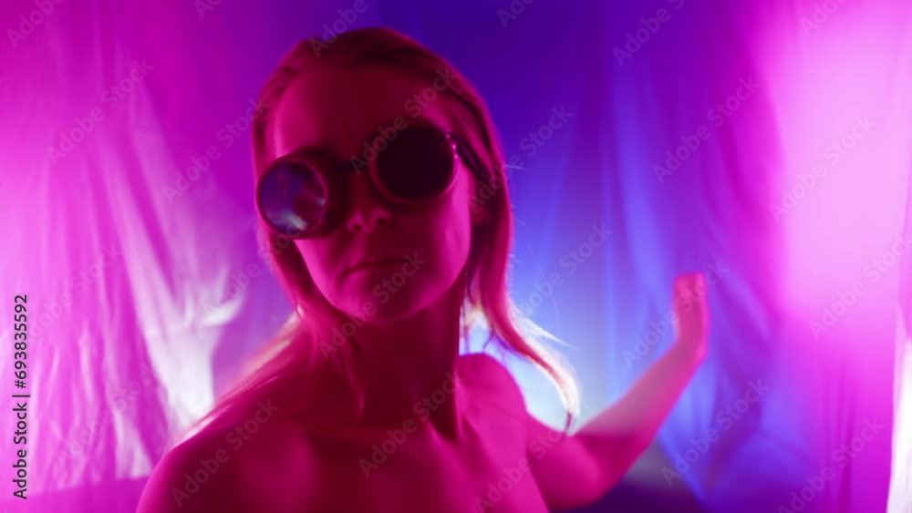 A nude girl wearing glasses and illuminated by pink light, dances in a cyberpunk style. She is very active and graceful. High quality 4k footage A nude girl wearing glasses and illuminated by pink light, dances in a cyberpunk style. She is very active and graceful. High quality 4k footage