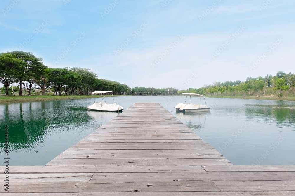 Wooden bridge in pond and boat.