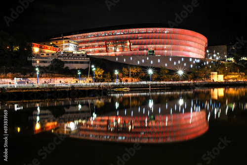 Long exposure night shot of the San Mamés Stadium in Bilbao. Spain. Beautiful colorful reflections on the Nervión river (river of the Basque Country).