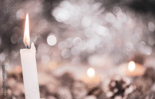 A burning candle with bright festive background and copy space