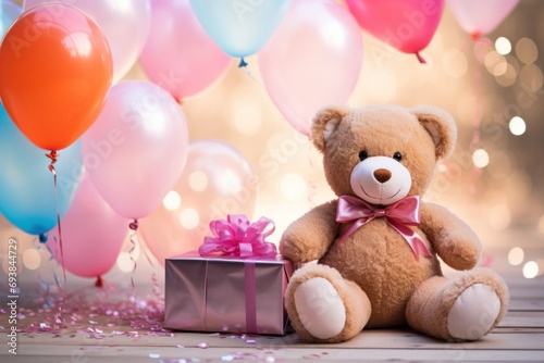 pink teddy bear sitting with balloons