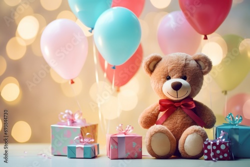 pink teddy bear sitting with balloons