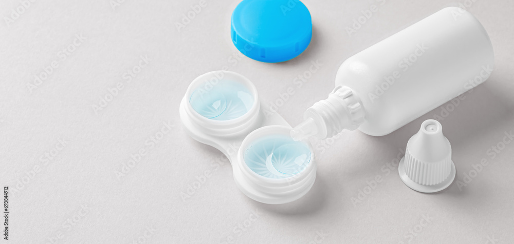 Contact lenses in container with solution bottle o on beige background Contact lenses in container with solution bottle o on beige background
