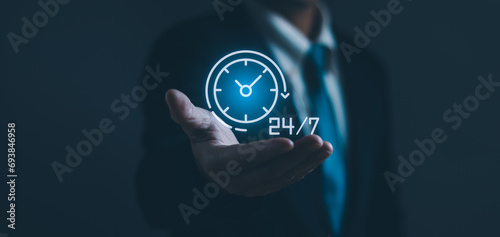 Businessman's hands holding virtual 24-7 with clock on hand For non-stop and full-time contact customer service ,concept oFnon-stop service Digital marketing hotline with wireless technology