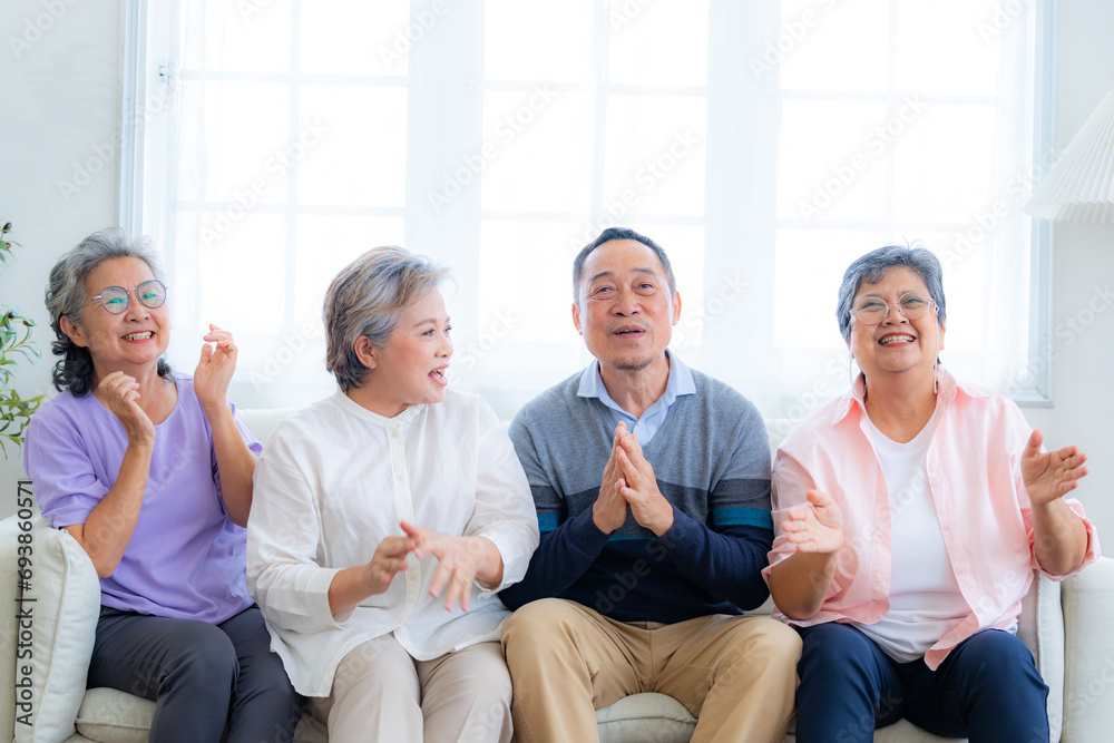Happiness of the group females and male elderly sitting on the sofa. Senior people are talking and enjoy together at the living room. Joyful carefree retired senior friends enjoying relaxation.