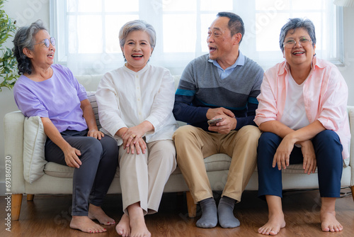 Happiness of the group females and male elderly sitting on the sofa. Senior people are talking and enjoy together at the living room. Joyful carefree retired senior friends enjoying relaxation.