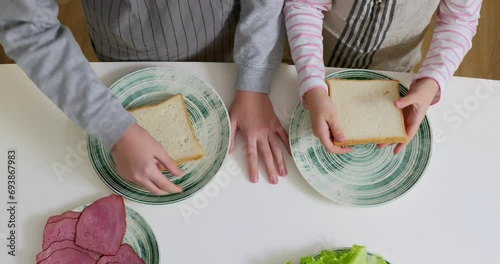 Boy and girl making sandwiches on the kitchen. photo