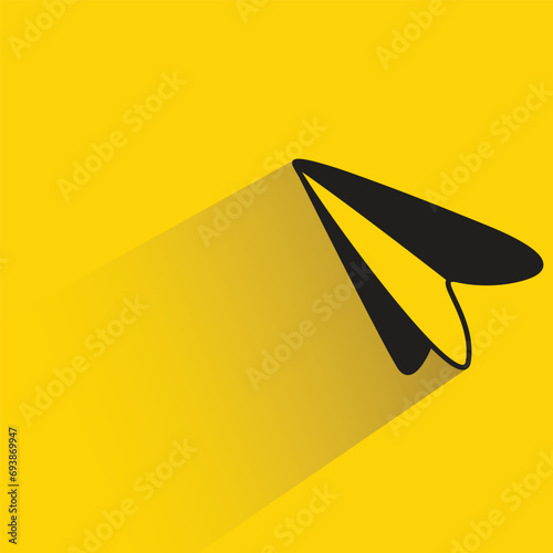 paper plane with shadow on yellow background
