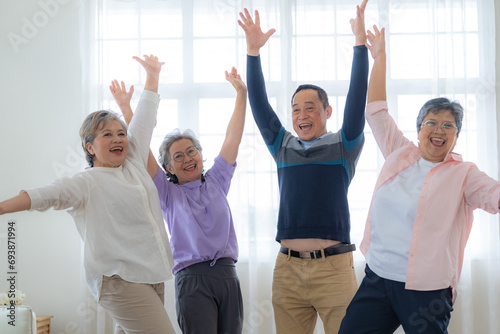 Group of Senior Retirement Friends Happiness Concept. Elderly people put hands together and cheer up. Seniors are moving their body arms and shoulders. retired people activities group concept.