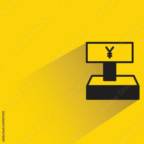 Yuan cashier machine with shadow on yellow background