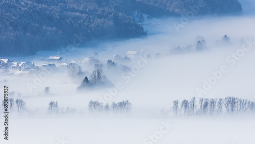 Ground fog covering farmland and trees on a beautiful winter landscape © Photofex