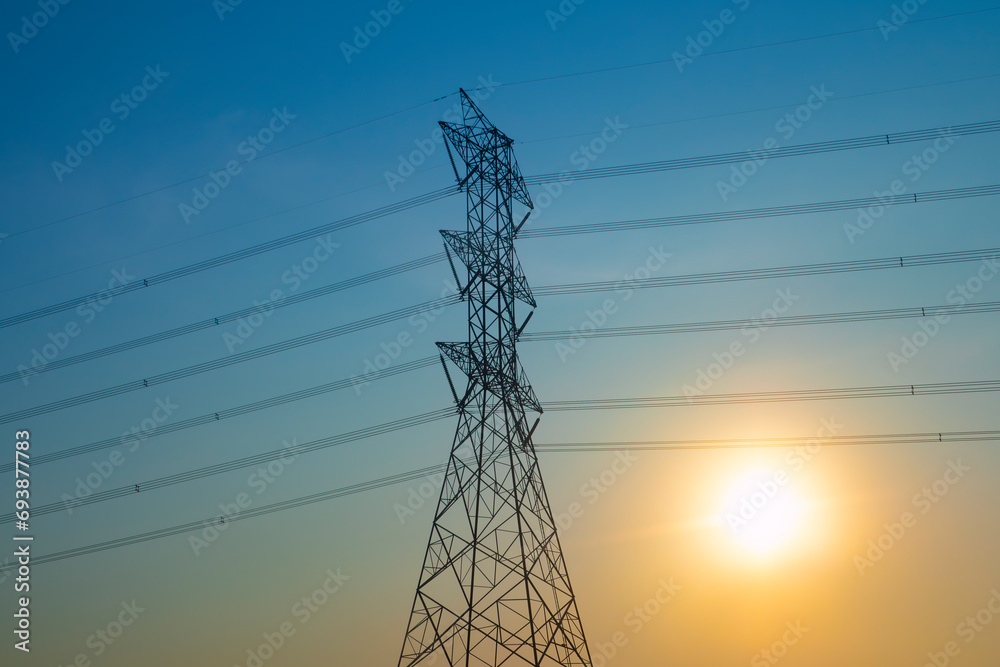 High voltage poles and the sun in the background. Electricity generation business. Energy demand.energy crisis and global warming