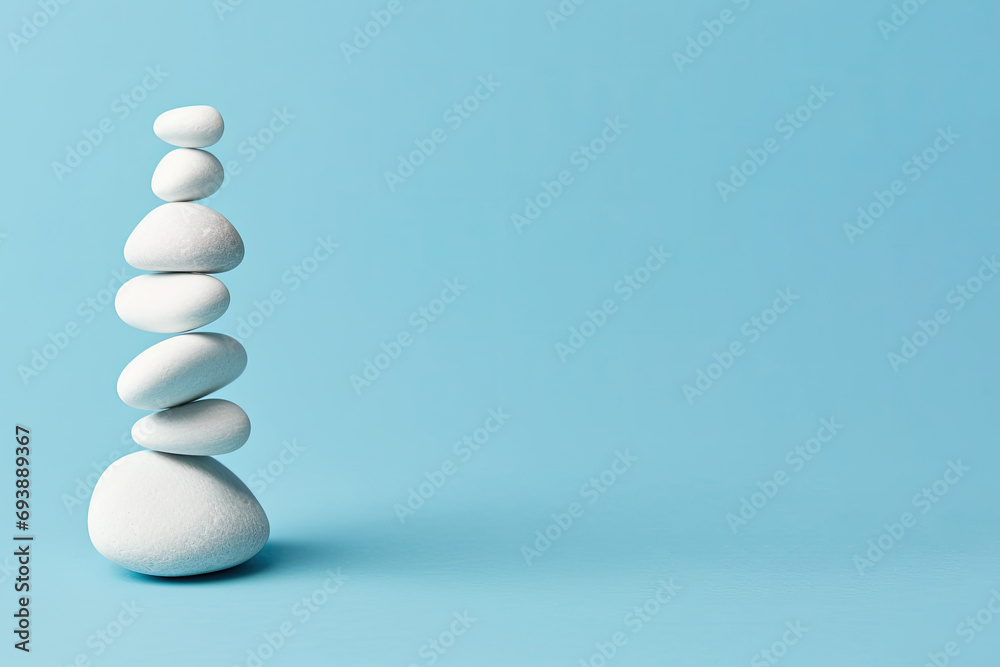  White sea pebble stone stack on light blue background. stack of zen stones on blue . copy space for text - obrazy, fototapety, plakaty 