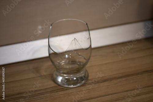 Broken transparent drinking glass in the kitchen. Sharp dangerous pieces. © julianeroznak