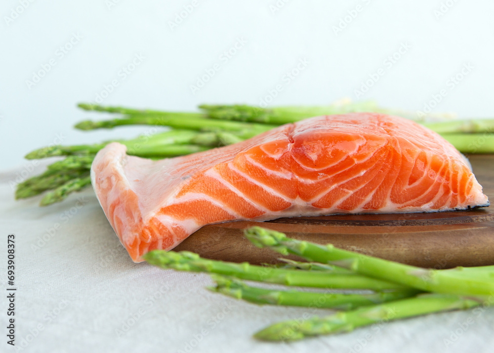 raw salmon and asparagus on a cutting board raw salmon and asparagus on a cutting board