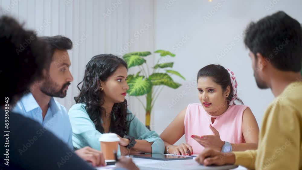 Businesswoman or employee at meeting confidently speaking or guiding team members at office - concept of leadership communication, startup discussion and motivation Businesswoman or employee at meeting confidently speaking or guiding team members at office - concept of leadership communication, startup discussion and motivation