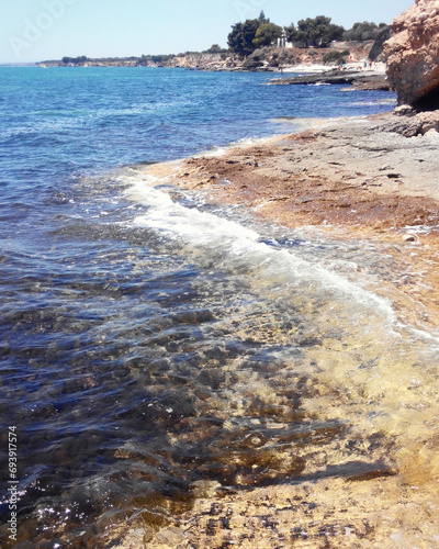 Chiancamasitto on the Gargano: rocks and sea in a romantic dance. Waves gently caress the coast, creating a tranquil atmosphere.