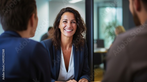Handshake between smiling businesswoman and client at office meeting. Mid aged female manager or hr hiring new recruit, bank or insurance agent, or lawyer making contract deal at work