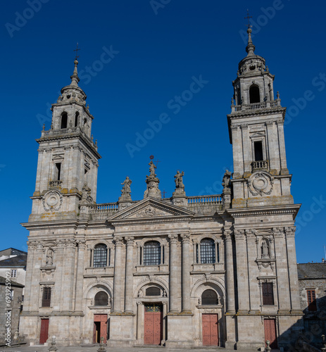 The historic cathedral of Lugo, Spain with twin towers against a clear blue sky.