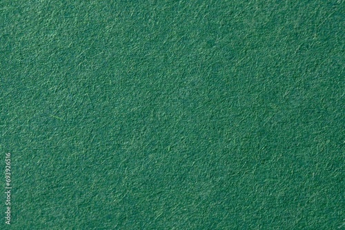 Dark green fluffy velvet texture background. Green velvet fabric photo
