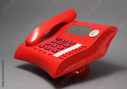 Close up telephone landline isolated at office concept. Stylish curvy design, red color, Italian modern design concept. 