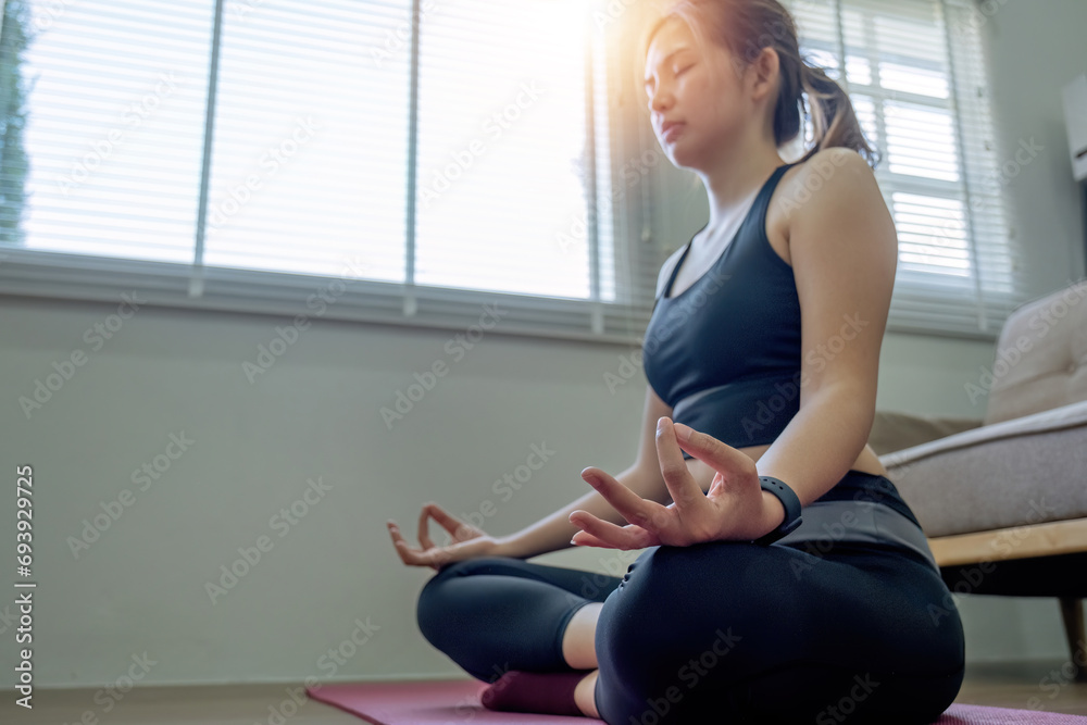 Young Asian woman practicing yoga at home in various poses sitting on the living room floor The concept of rest, relaxation, exercise.