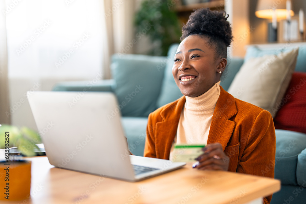 Happy satisfied woman paying with credit card while shopping online over laptop and relaxing the floor at home. Happy satisfied woman paying with credit card while shopping online over laptop and relaxing the floor at home.