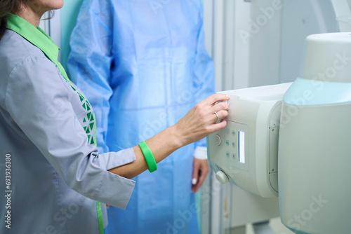 Qualified radiologic technologist preparing patient for radiographic examination