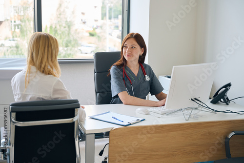 Doctor entering patient data into electronic health record during consultation photo