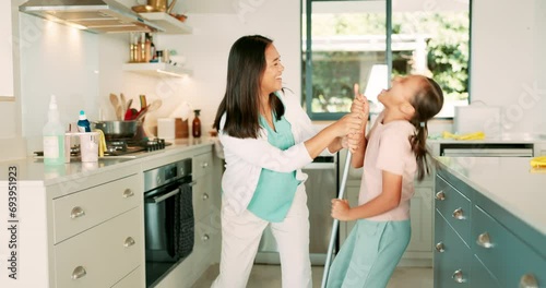 Cleaning, mom and girl dance in the kitchen with a broom, sweeping and or fun housework with music in family home. Kid, learning to clean floor and mother with happy and excited energy in house photo